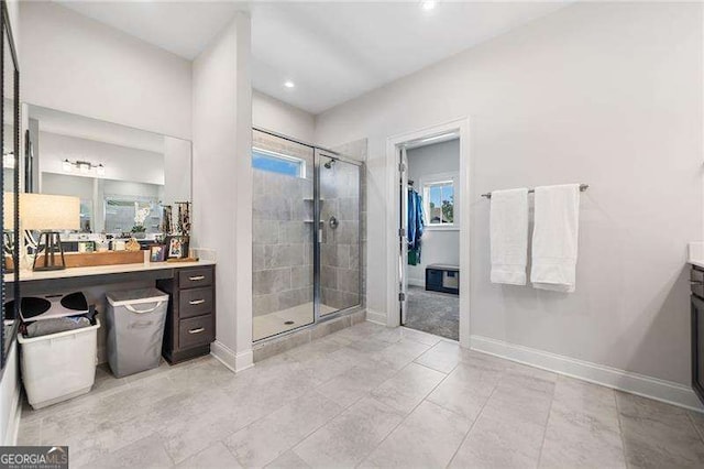 bathroom featuring vanity, a healthy amount of sunlight, and a shower with shower door