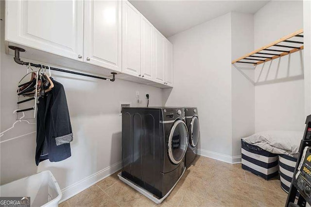 laundry room featuring washer and clothes dryer and cabinets