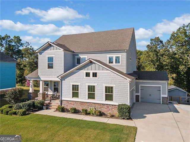 craftsman-style home featuring a garage, covered porch, and a front lawn