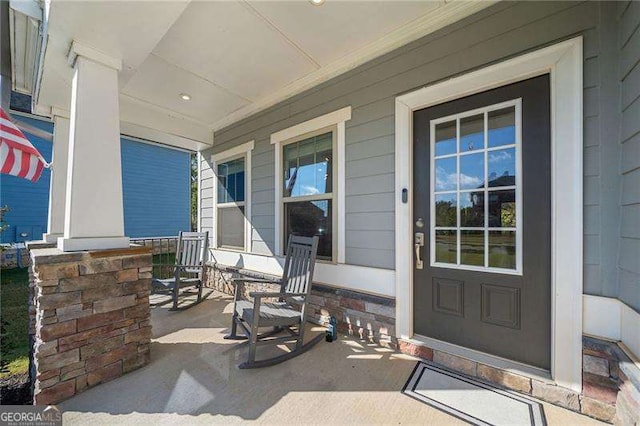 view of exterior entry featuring covered porch