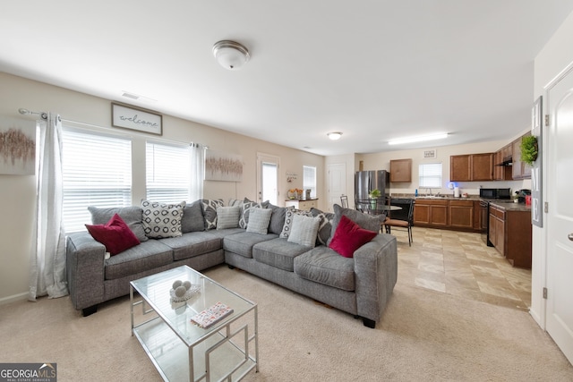 living room featuring sink and light colored carpet