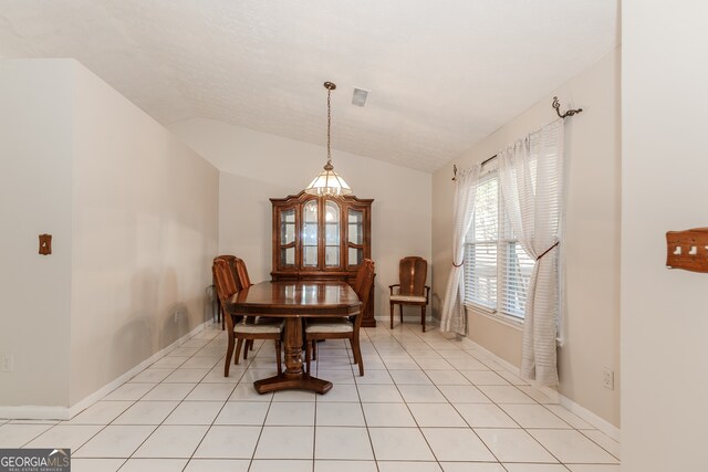 tiled dining space with vaulted ceiling