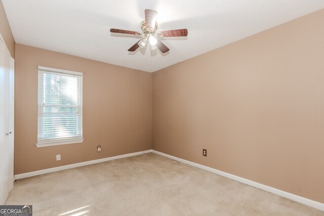 unfurnished room featuring light colored carpet and ceiling fan