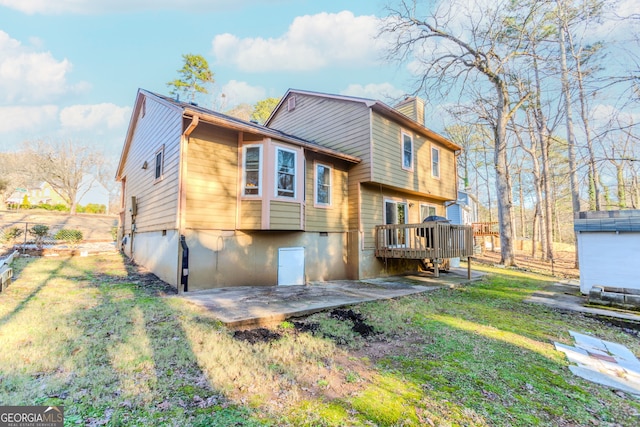 rear view of house with a lawn, a patio, and a wooden deck