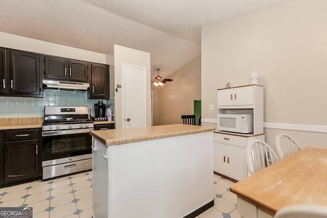 kitchen featuring ceiling fan, stainless steel range, backsplash, vaulted ceiling, and a kitchen island