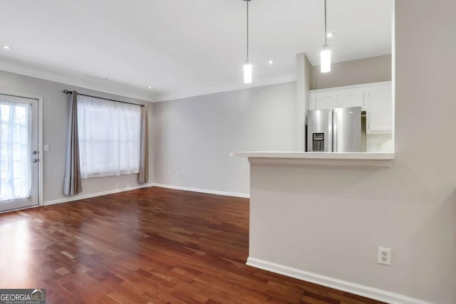 unfurnished living room featuring dark wood-type flooring and ornamental molding