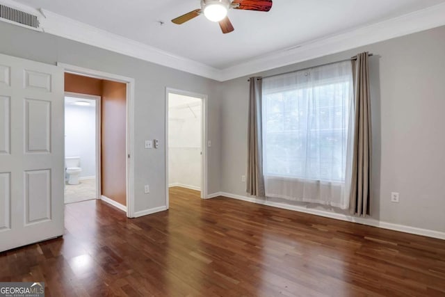 interior space with ceiling fan, ornamental molding, and dark wood-type flooring