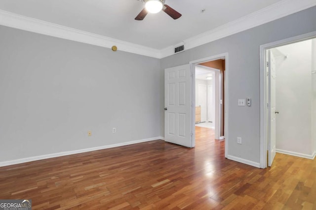 unfurnished bedroom featuring hardwood / wood-style floors, ceiling fan, and crown molding