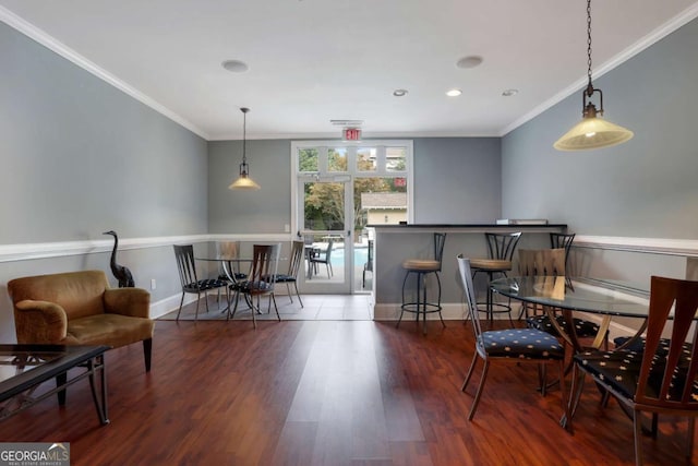 dining space featuring hardwood / wood-style floors and crown molding