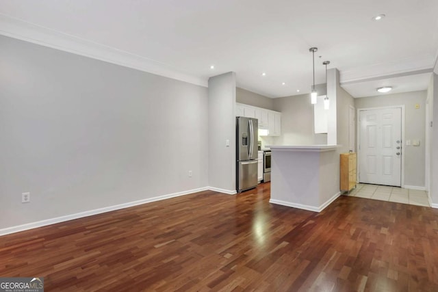 kitchen featuring kitchen peninsula, stainless steel appliances, pendant lighting, hardwood / wood-style floors, and white cabinetry