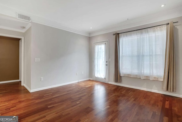 spare room featuring ornamental molding and dark wood-type flooring