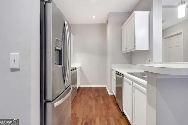 kitchen featuring white cabinets, stainless steel appliances, and light hardwood / wood-style flooring