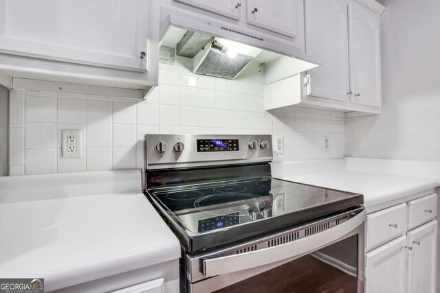 kitchen with backsplash, white cabinets, and stainless steel electric range