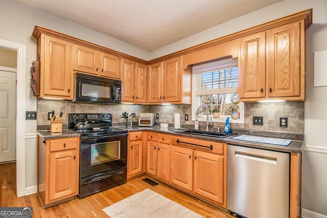 kitchen featuring black appliances, sink, tasteful backsplash, and light hardwood / wood-style flooring