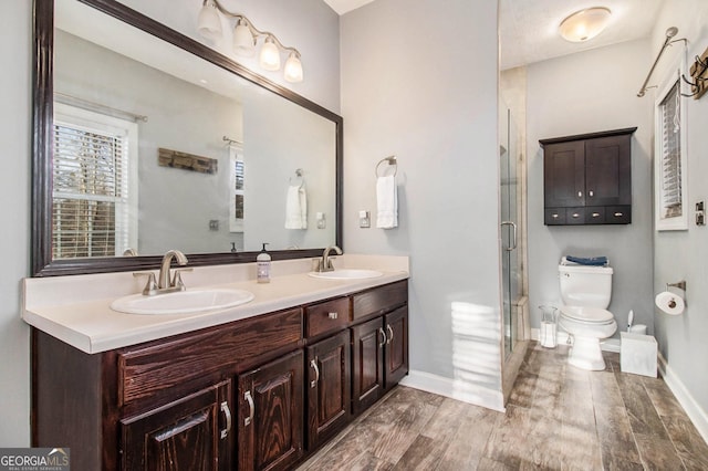 bathroom featuring toilet, a shower with door, wood-type flooring, and vanity