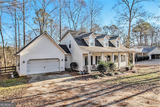 cape cod-style house featuring covered porch and a garage