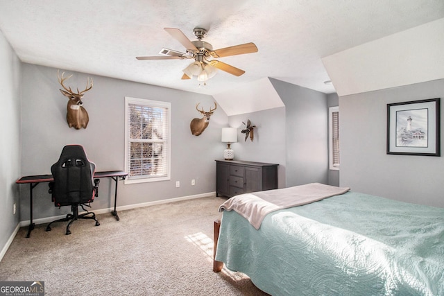 bedroom featuring ceiling fan, vaulted ceiling, light carpet, and a textured ceiling