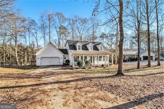 cape cod-style house with a garage and covered porch