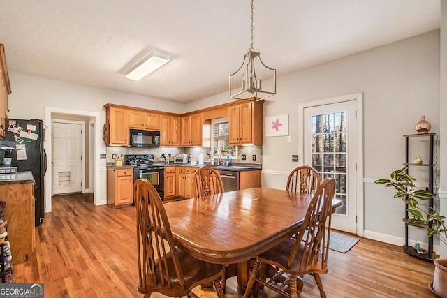 dining area featuring a chandelier, light hardwood / wood-style flooring, and sink