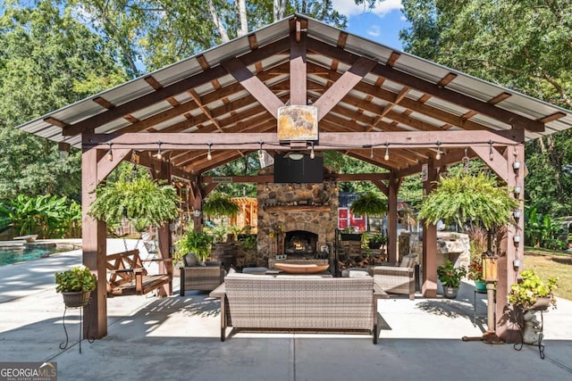 view of patio / terrace with an outdoor living space with a fireplace and a gazebo