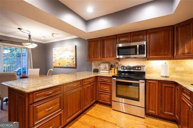 kitchen featuring tasteful backsplash, stainless steel appliances, and kitchen peninsula