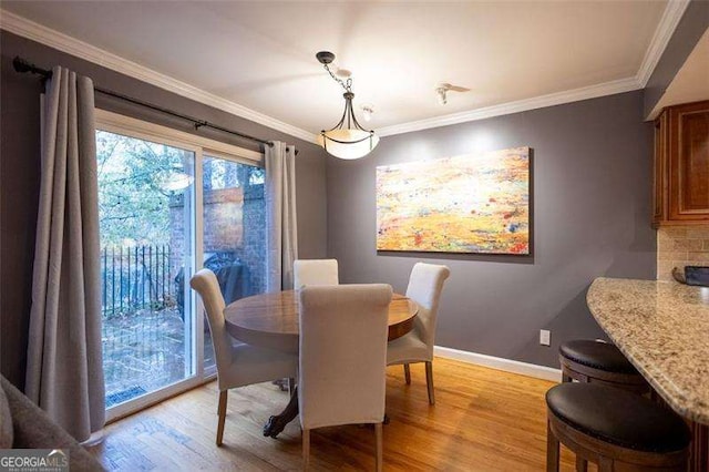 dining room with light hardwood / wood-style flooring and ornamental molding