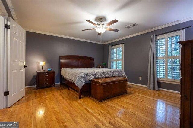 bedroom with crown molding, ceiling fan, and light wood-type flooring