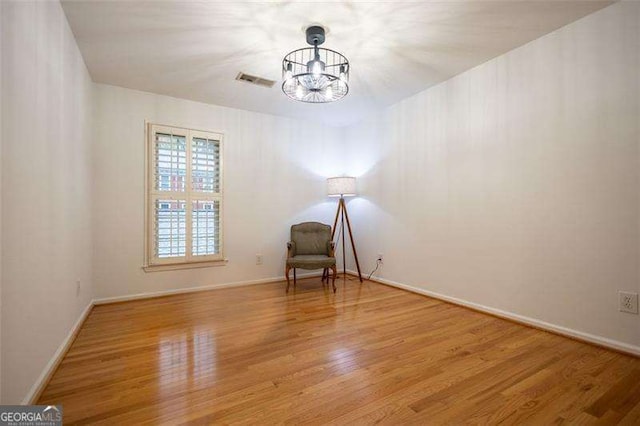 unfurnished room featuring wood-type flooring and a chandelier