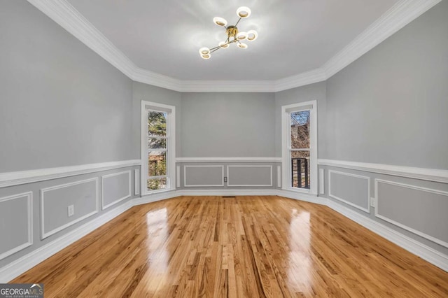 unfurnished dining area with crown molding, light hardwood / wood-style flooring, and an inviting chandelier