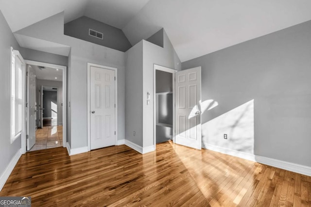 unfurnished bedroom featuring hardwood / wood-style floors and vaulted ceiling