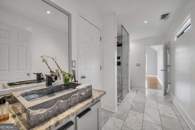 bathroom featuring vanity and a shower with shower door