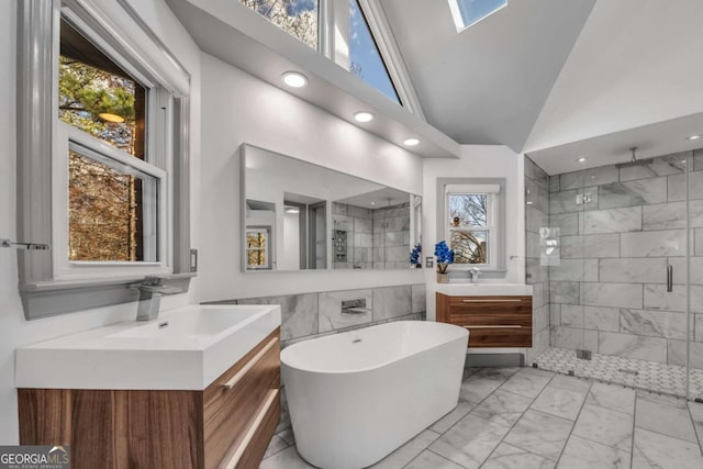 bathroom featuring vanity, independent shower and bath, and vaulted ceiling