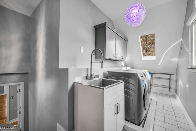 laundry area with cabinets, a skylight, sink, light tile patterned floors, and independent washer and dryer