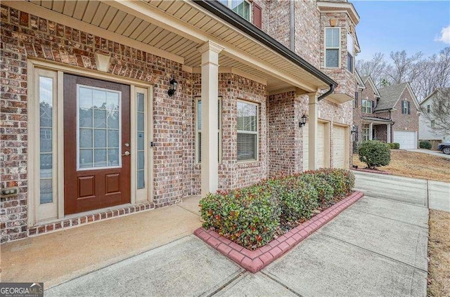 view of exterior entry featuring a porch and a garage