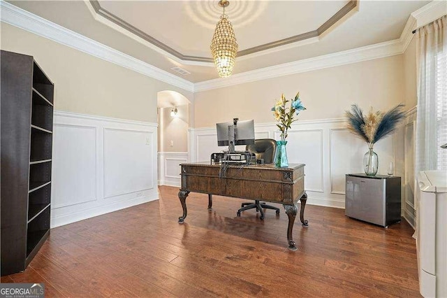 office with dark hardwood / wood-style flooring, a raised ceiling, ornamental molding, and an inviting chandelier