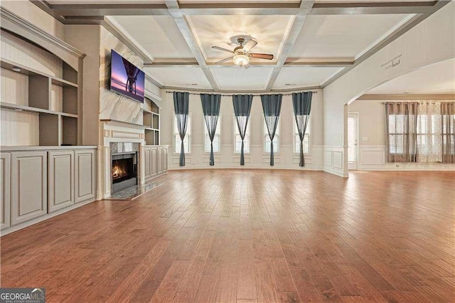 unfurnished living room featuring coffered ceiling, ceiling fan, wood-type flooring, built in features, and a fireplace