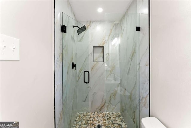 bathroom featuring an enclosed shower and toilet