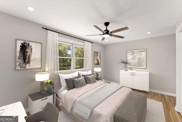 bedroom with ceiling fan and light hardwood / wood-style floors