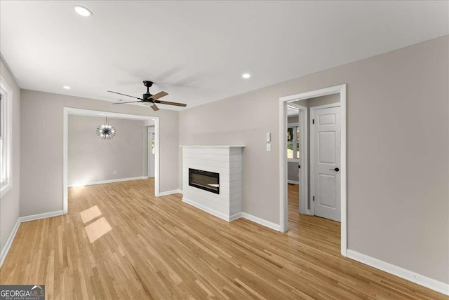 unfurnished living room with ceiling fan, a wealth of natural light, and light wood-type flooring