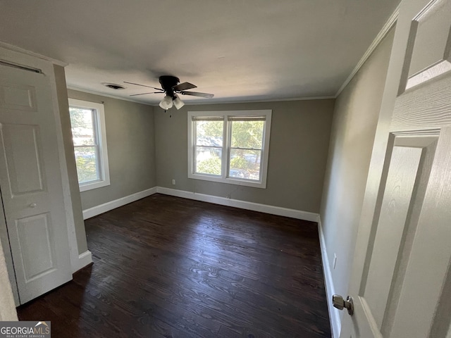 empty room with dark hardwood / wood-style floors, ceiling fan, and ornamental molding