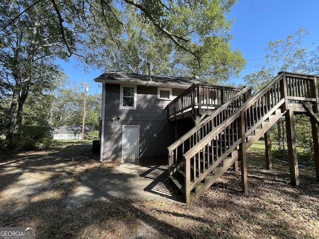 rear view of property featuring a wooden deck