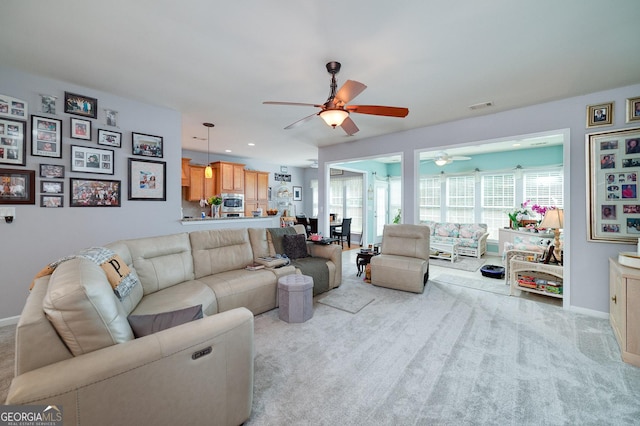 carpeted living room with ceiling fan