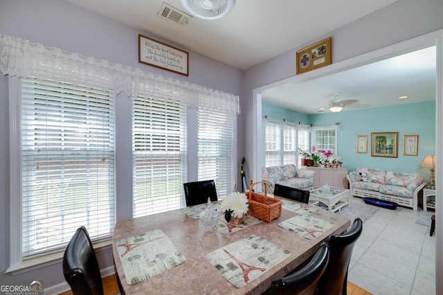 tiled dining space featuring plenty of natural light and ceiling fan