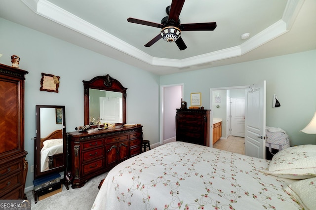 bedroom with a raised ceiling, connected bathroom, ceiling fan, and crown molding