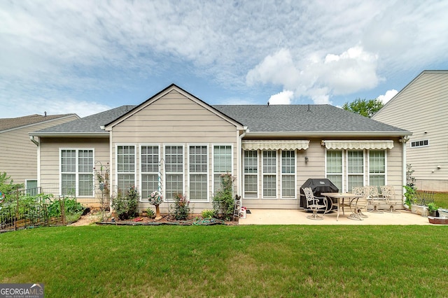 back of property with a yard and a patio