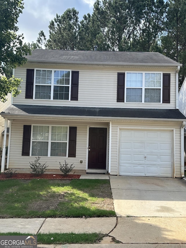 front of property with a garage and a front lawn