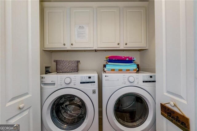 clothes washing area featuring cabinets and independent washer and dryer