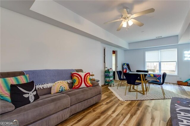 living room with wood-type flooring and ceiling fan