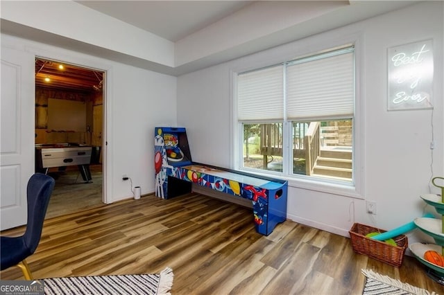 recreation room with baseboards and wood finished floors
