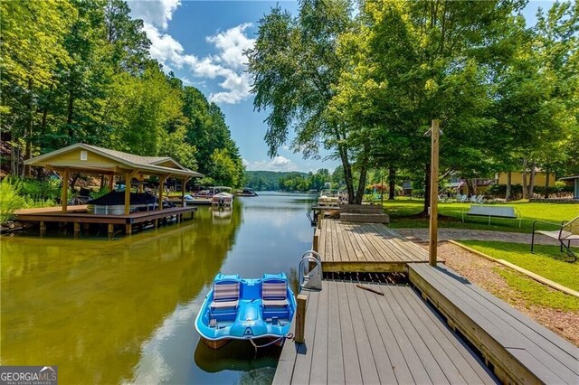 dock area with a lawn and a water view